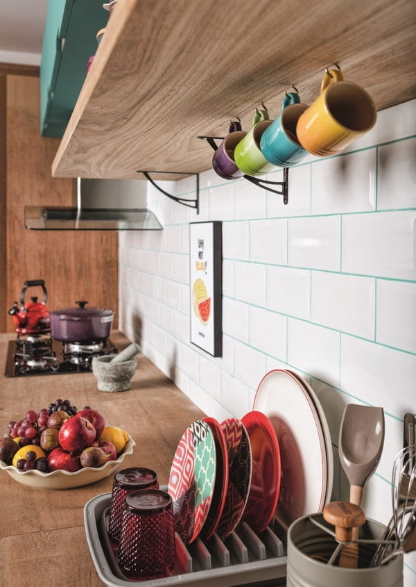 Tazas de colores colgadas de un estante en la cocina